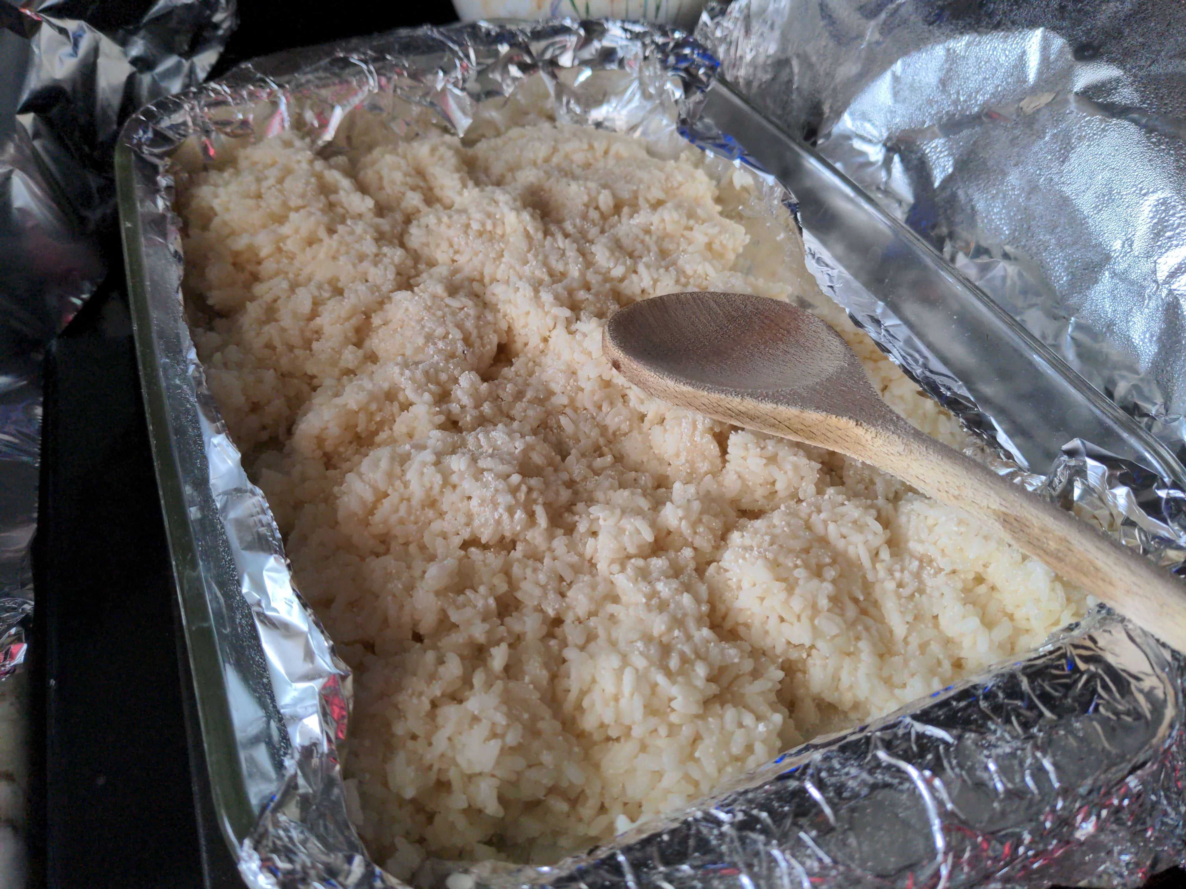 A glass container with cooked rice that's already dusted with bubod. It's ready to go into fermentation.