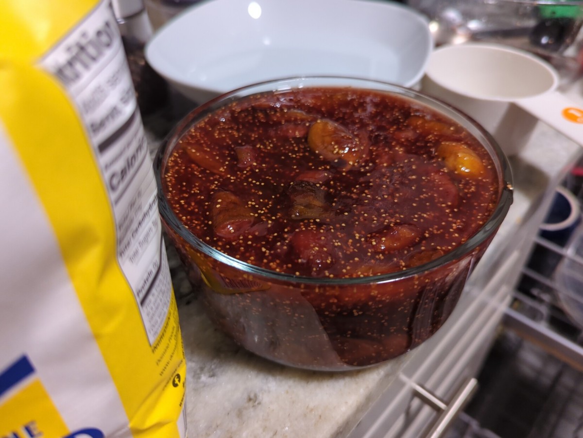 The finished fig jam in a glass container. You can still see pieces of fig in there, but it's mostly all cooked down into a jam.