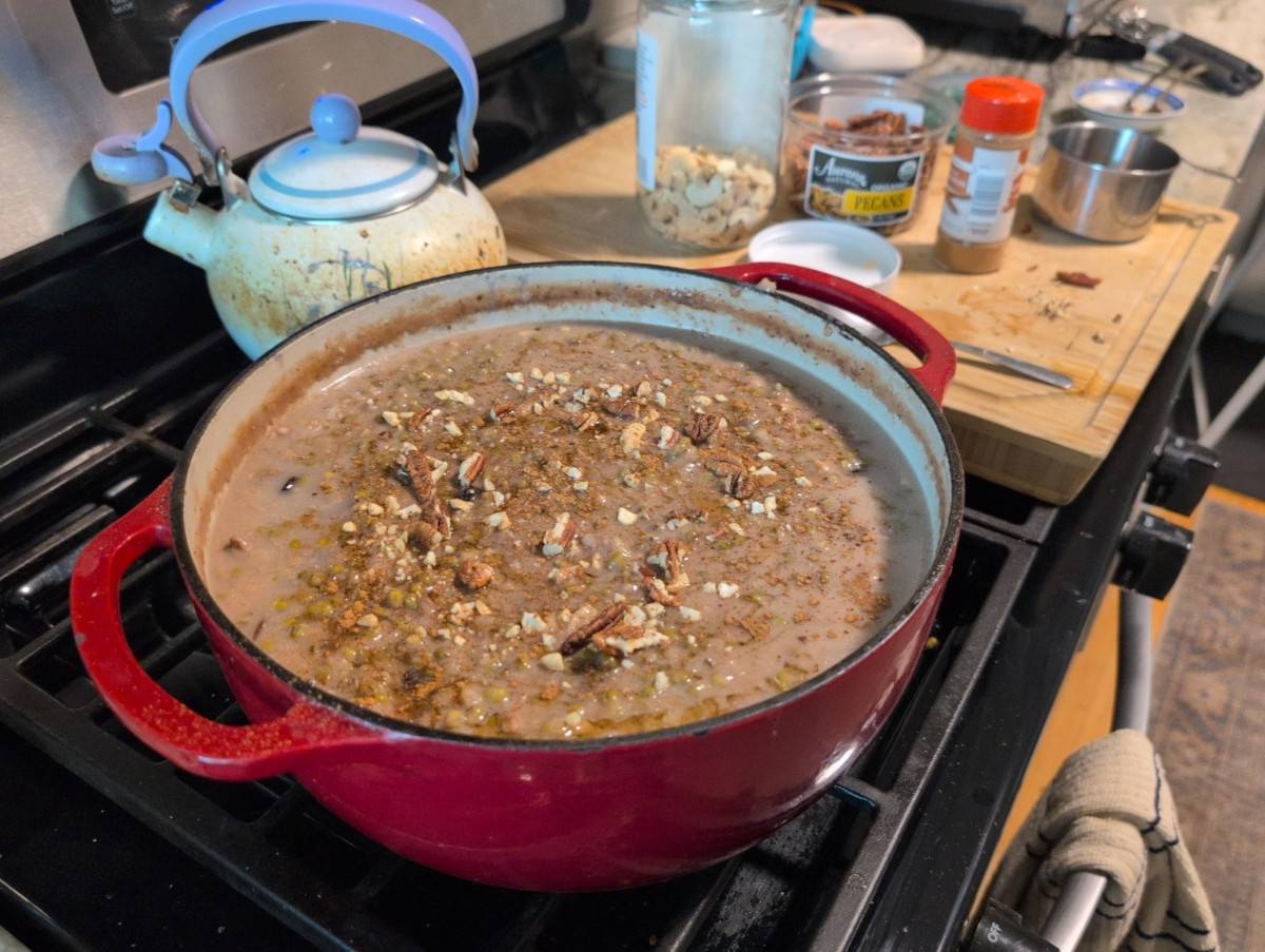 A large pot of ginataang monggo kheer with various nuts and cinnamon powder on top of it